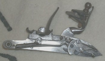 Inside the lock of a replica Brown Bess musket at half cock. Image courtesy of Dan.